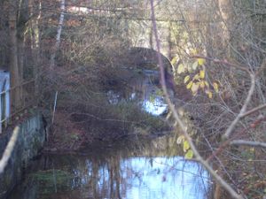 Die Tonnenbrücke am Untergraben, dahinter die früheren 6 Reinigungsreiche (Klärteiche, heute Schrottverwertung).